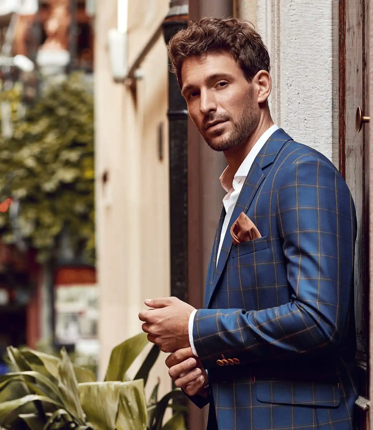 Homme portant un blazer motif Prince de Galles, accessoirisé avec sobriété