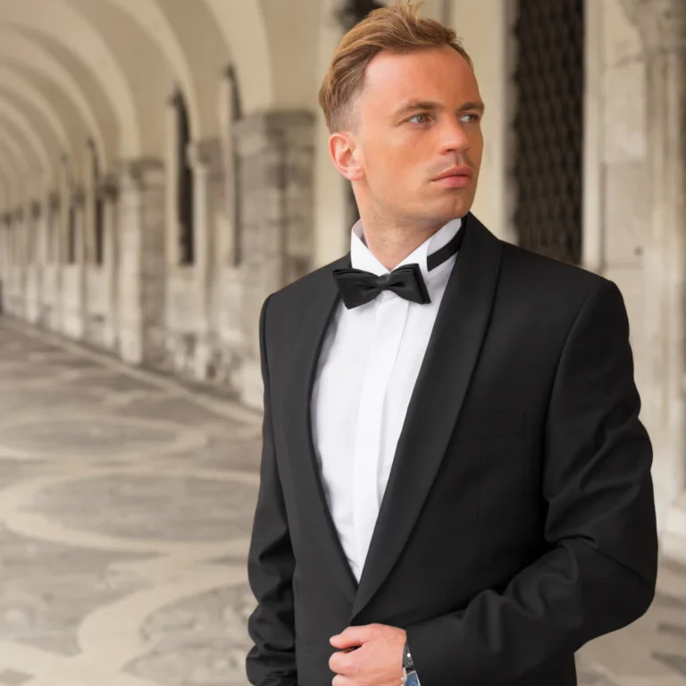 Homme élégant en smoking noir avec nœud papillon lors d’une soirée formelle