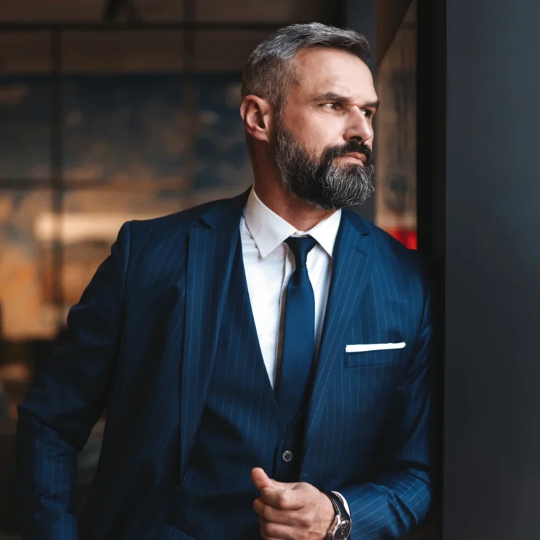 Homme élégant en costume sur mesure bleu marine dans un décor urbain